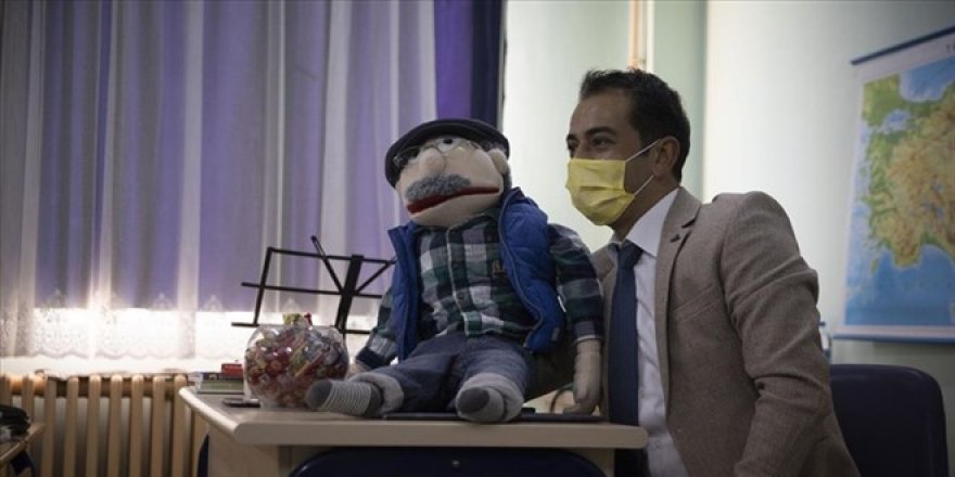 Mahir öğretmen kukla gösterisi ve şarkılarla ders işliyor